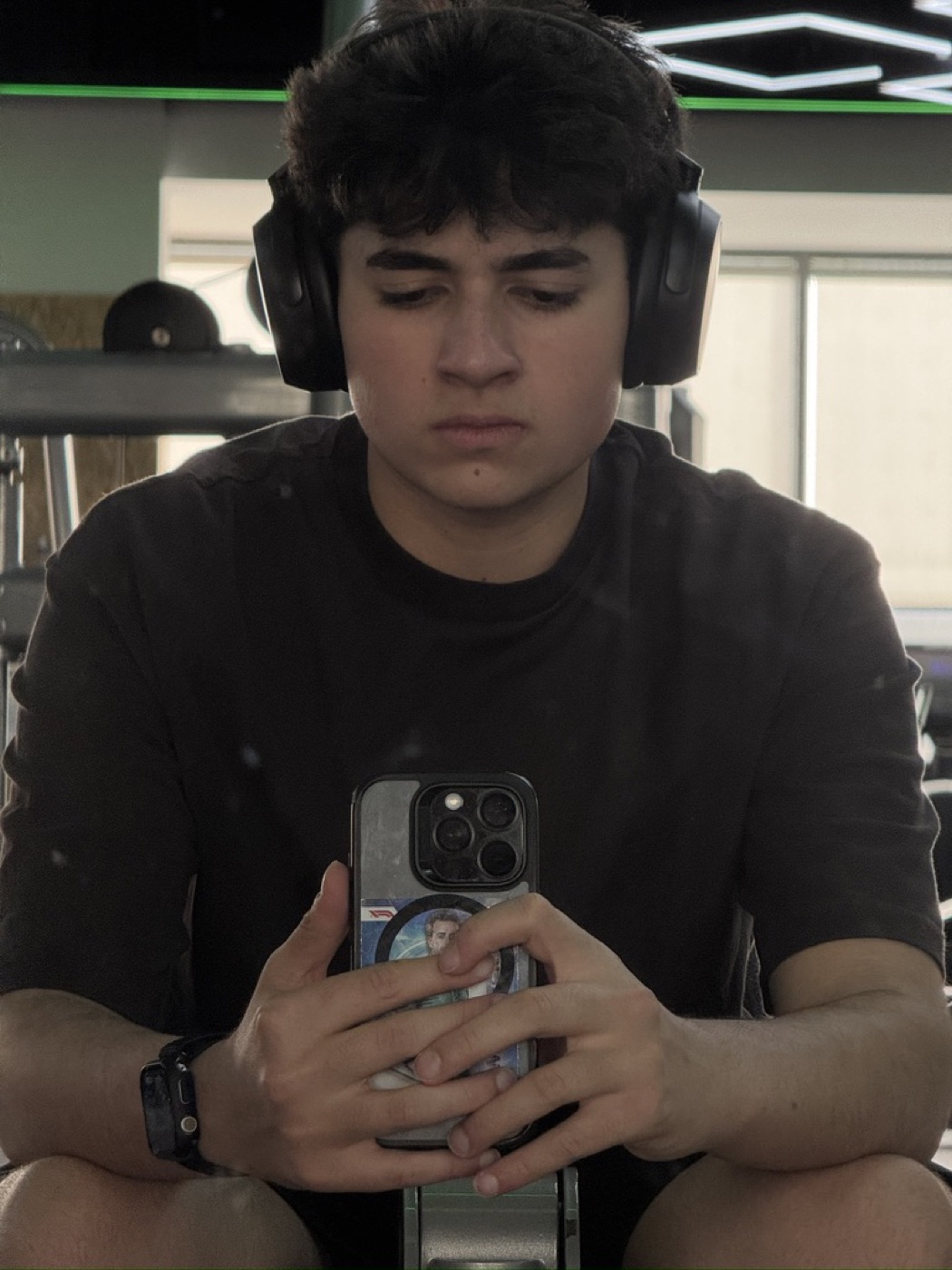 abdullah sultan sitting in a gym wearing over-ear headphones